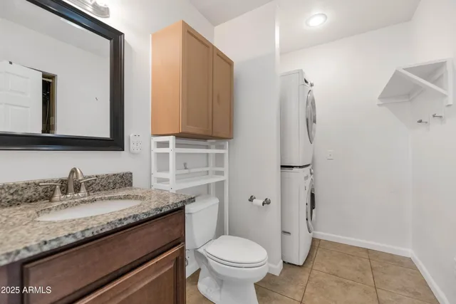 a bathroom with a granite countertop toilet sink and mirror