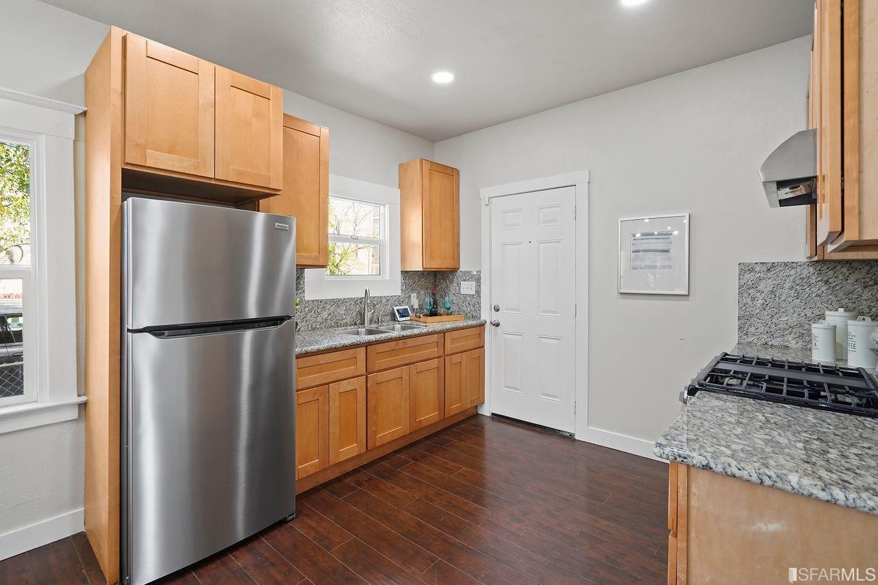 3036 14th Avenue Oakland, CA 94602 - Photo 23 of 35 a kitchen with stainless steel appliances granite countertop a refrigerator and a stove top oven