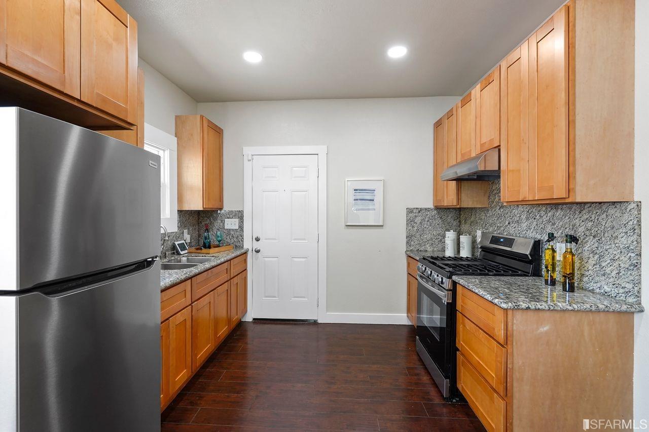 3036 14th Avenue Oakland, CA 94602 - Photo 25 of 35 a kitchen with stainless steel appliances granite countertop a refrigerator a stove a sink and a microwave