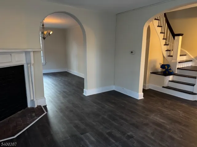 a view of a livingroom with wooden floor and a fireplace