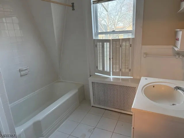 a bathroom with a tub sink and window
