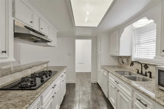 a kitchen with stainless steel appliances granite countertop a sink stove and cabinets