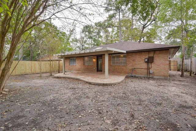 a view of a house with a yard and large tree