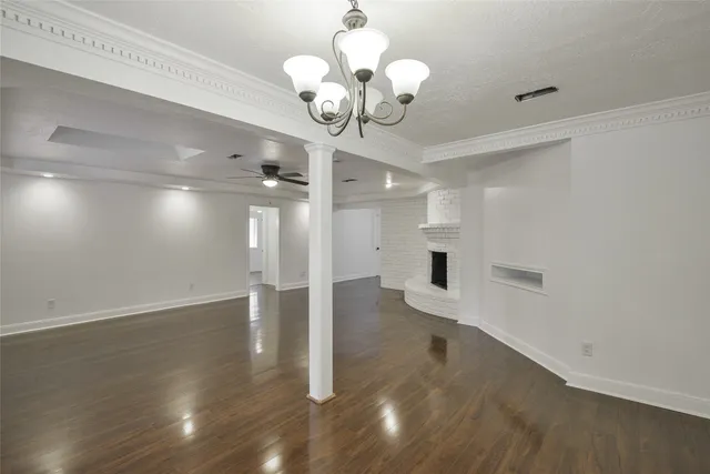 a view of a hallway with wooden floor and a chandelier