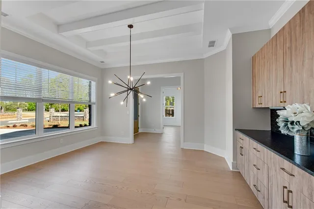 a view of an empty room with kitchen view and a window