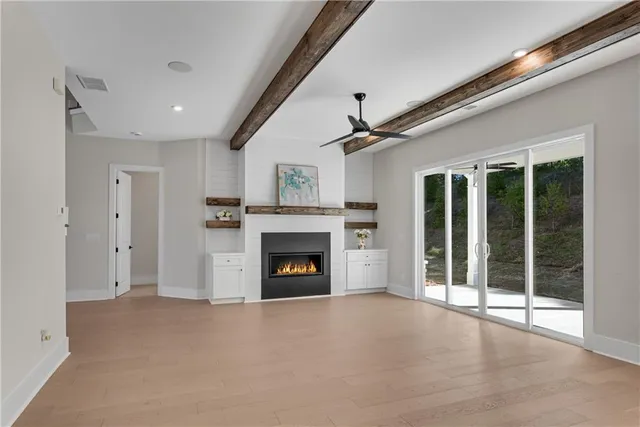 a view of an empty room with a fireplace and a window