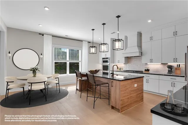 a large kitchen with stainless steel appliances granite countertop a stove a sink and a granite counter tops with white cabinets