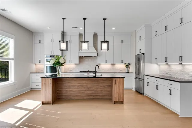 a kitchen with stainless steel appliances granite countertop a sink stove and refrigerator