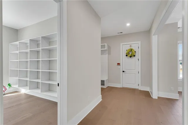 an empty room with ceiling fan and windows