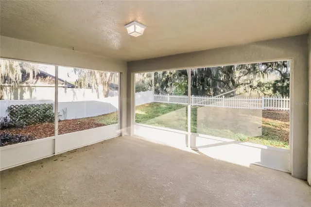 an empty room with floor to ceiling windows and outdoor view