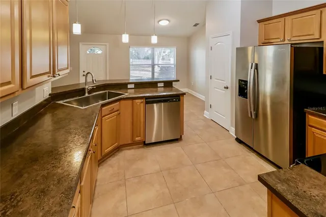 a large kitchen with kitchen island granite countertop a large counter top stainless steel appliances and cabinets