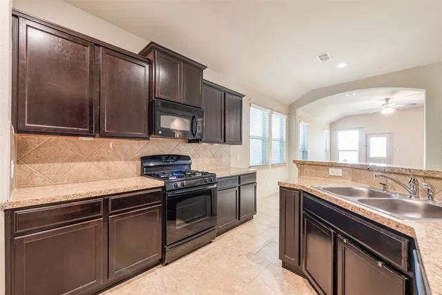a kitchen with granite countertop stainless steel appliances and wooden cabinets