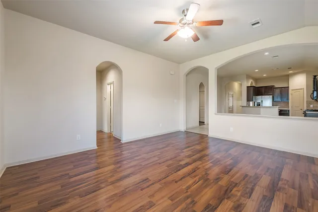 a view of an empty room with window and wooden floor