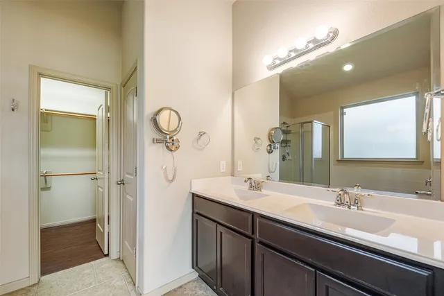 a bathroom with a double vanity sink mirror and shower