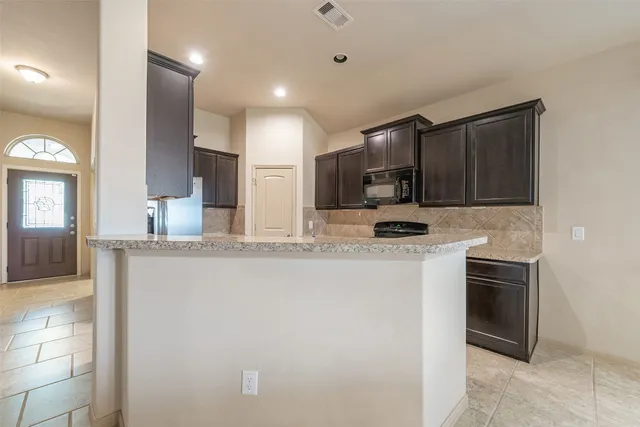 a kitchen with stainless steel appliances granite countertop a stove a sink and a refrigerator