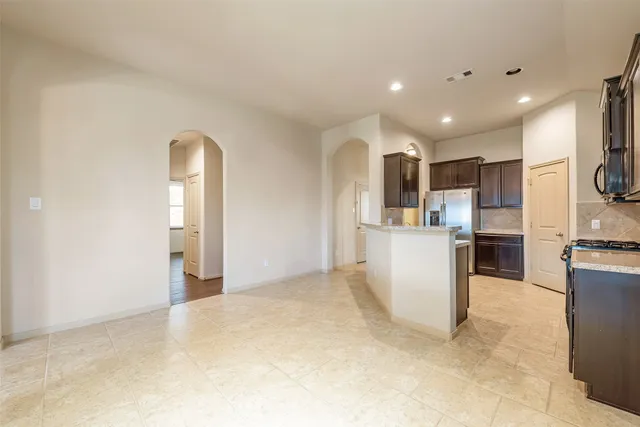 a view of a kitchen with a sink and dishwasher a refrigerator with wooden floor