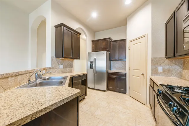 a kitchen with kitchen island granite countertop a sink stove and refrigerator