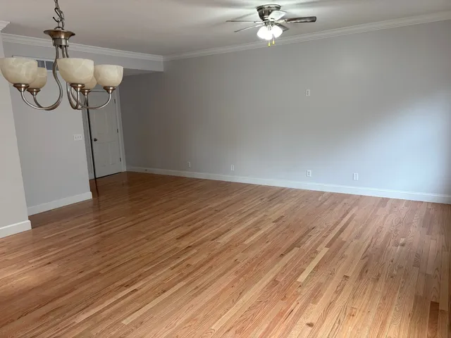a view of a room with wooden floor and ceiling fan