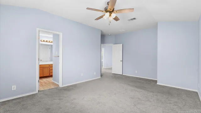 a view of an empty room and a ceiling fan