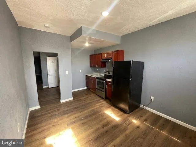 a kitchen with a refrigerator and a sink