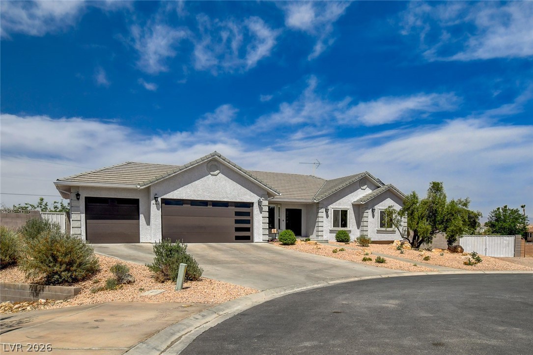 4362 Thistle Street Logandale, NV 89021 - Photo 2 of 99 A welcoming cul-de-sac home with a clean exterior and a modern three-car garage.