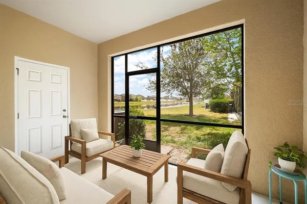 a living room with furniture and a floor to ceiling window