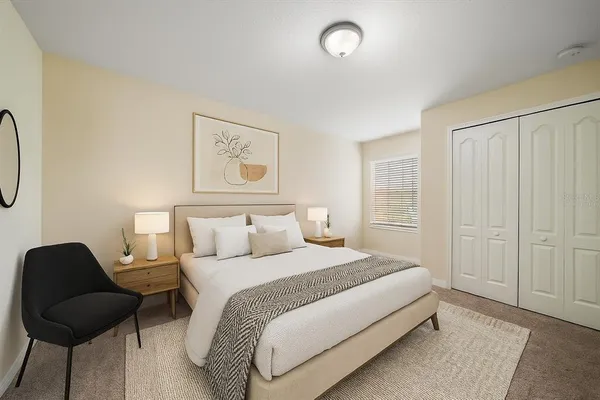 a spacious bedroom with a bed and a chair