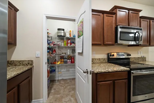 a kitchen with stainless steel appliances granite countertop a stove microwave and refrigerator