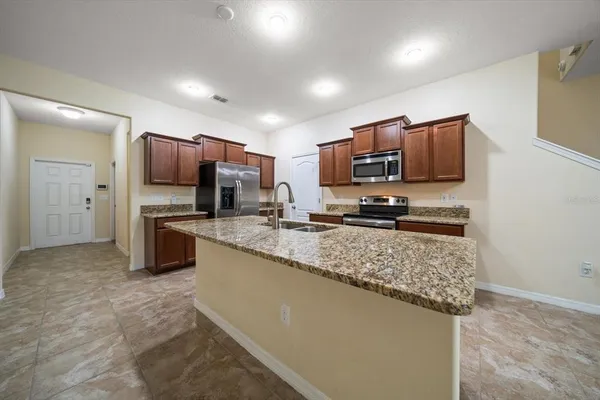 a kitchen with stainless steel appliances granite countertop a stove microwave and refrigerator