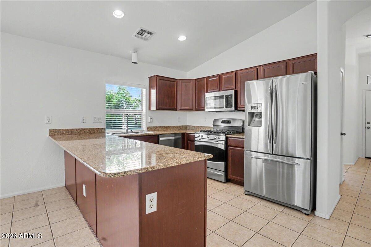 24726 North 29th Place Phoenix, AZ 85024 - Photo 6 of 31 a kitchen with stainless steel appliances granite countertop a refrigerator a sink a stove a microwave and island
