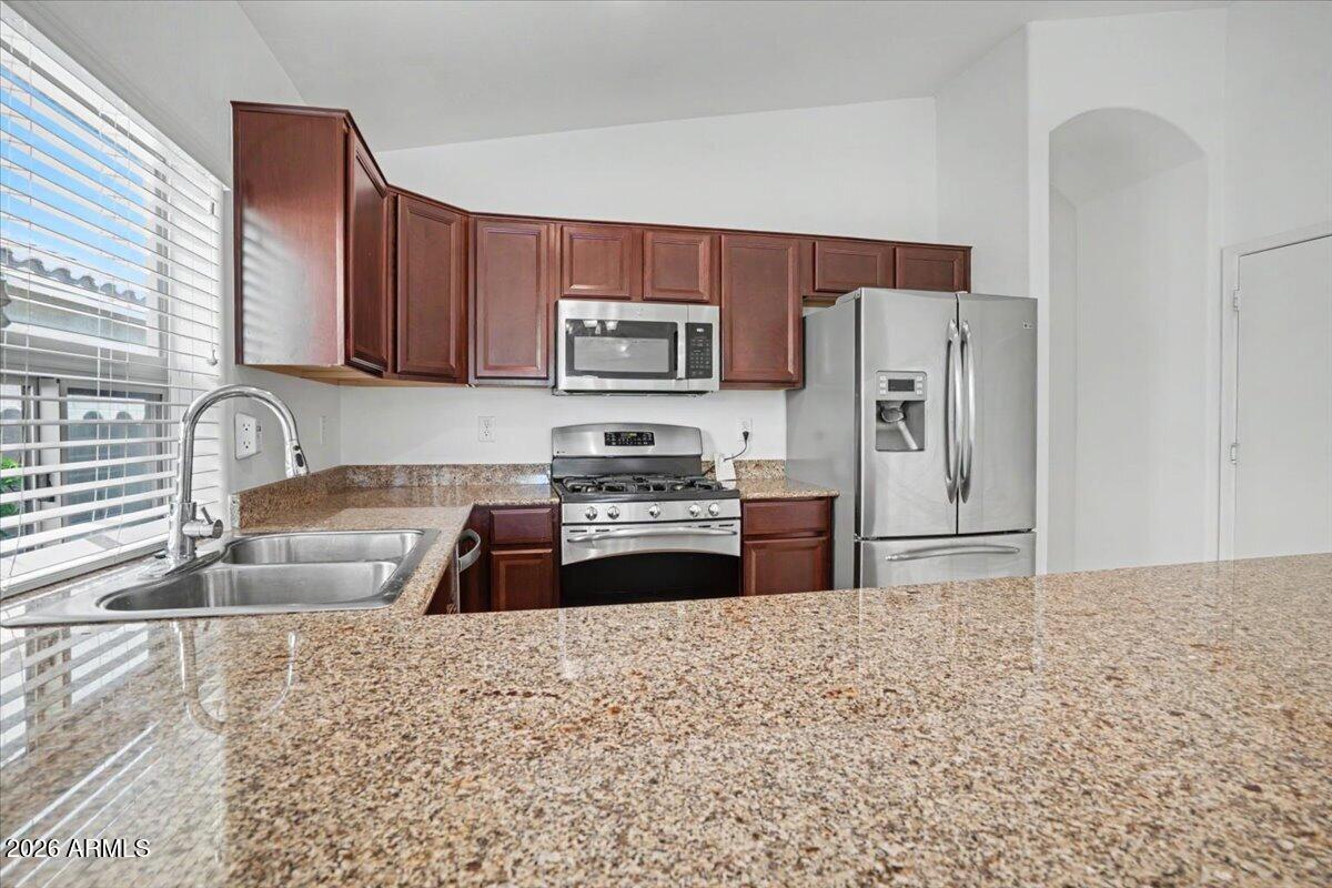 24726 North 29th Place Phoenix, AZ 85024 - Photo 7 of 31 a kitchen with granite countertop a refrigerator and a sink