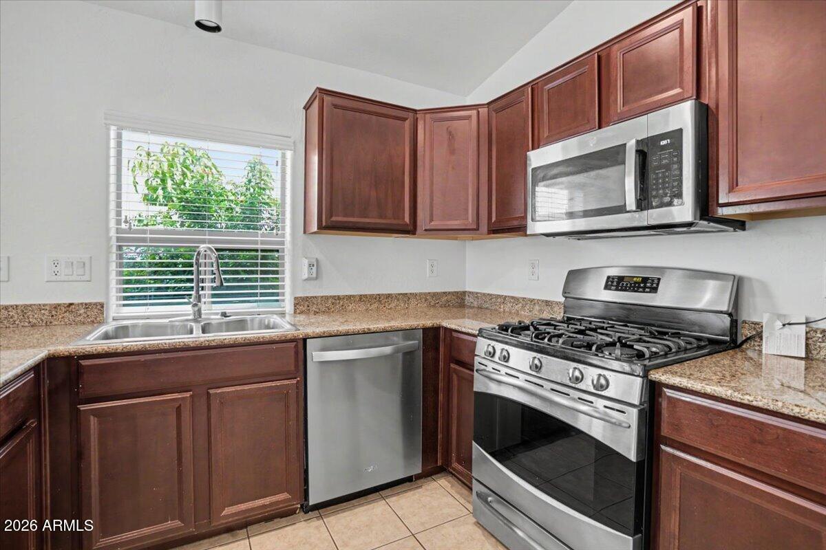 24726 North 29th Place Phoenix, AZ 85024 - Photo 8 of 31 a kitchen with granite countertop a stove sink and microwave