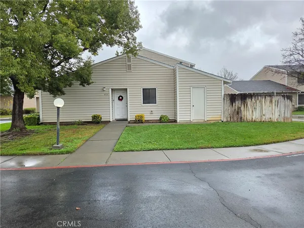 a view of a house with a yard and large tree