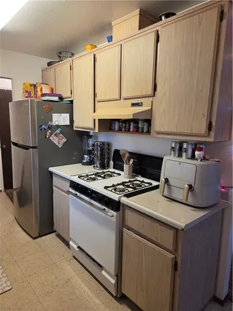a kitchen with a stove a refrigerator and a sink