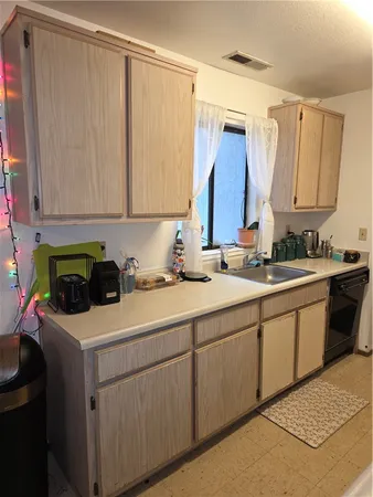 a kitchen with a sink cabinets and a window