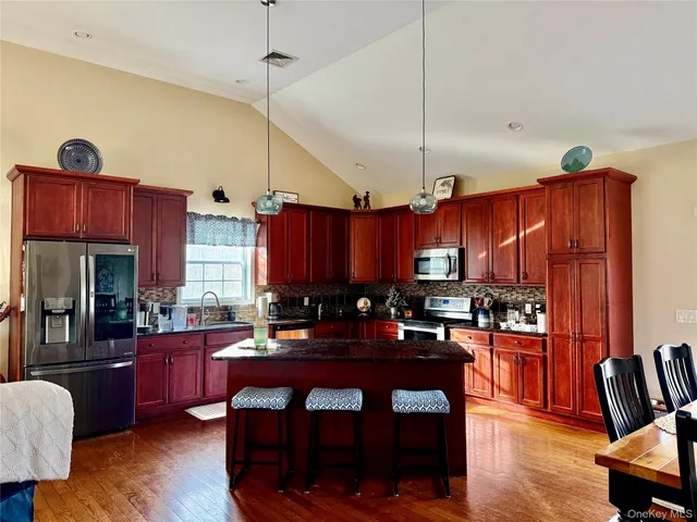 a kitchen with granite countertop a stove a sink dishwasher and a wooden cabinets