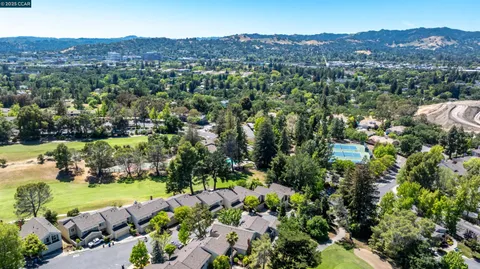 an aerial view of a houses with a yard and lake view