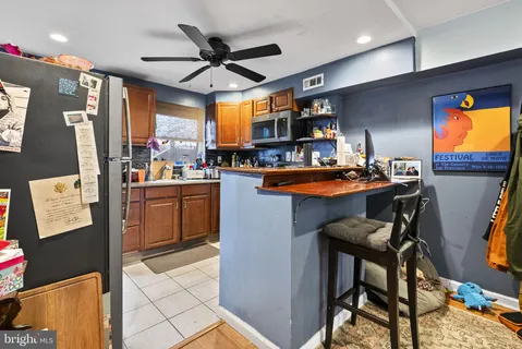 a room with stainless steel appliances kitchen island granite countertop furniture and a flat screen tv