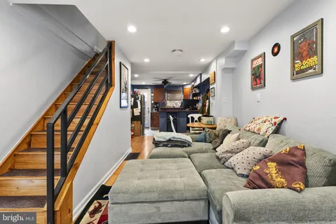 a living room with furniture and stairs