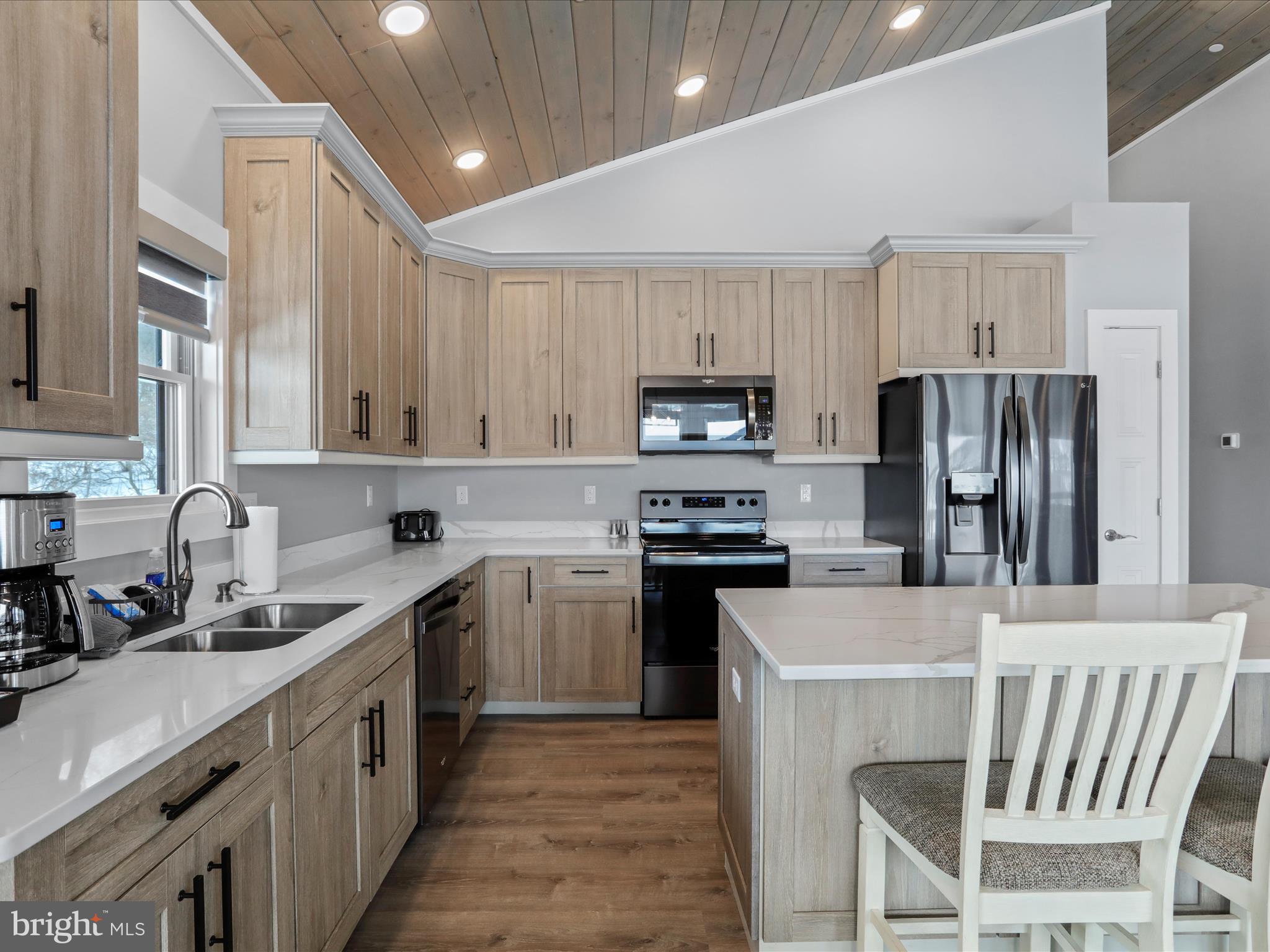 215 Fair Gate Road McHenry, MD 21541 - Photo 13 of 52 a kitchen with stainless steel appliances a sink a stove a refrigerator cabinets and a dining table