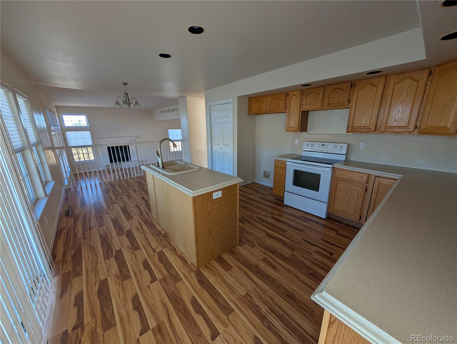 43882 Buckskin Road Parker, CO 80138 - Photo 6 of 19 a kitchen with sink cabinets and wooden floor