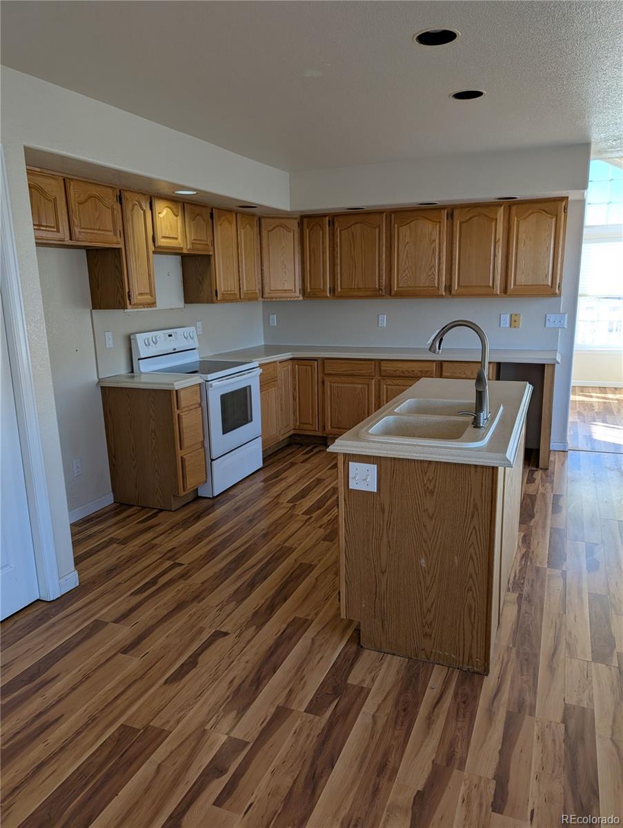 43882 Buckskin Road Parker, CO 80138 - Photo 8 of 19 a kitchen with stainless steel appliances granite countertop a sink a stove and wooden floors