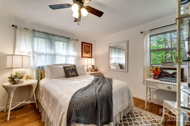 a bedroom with a bed a window and a chandelier