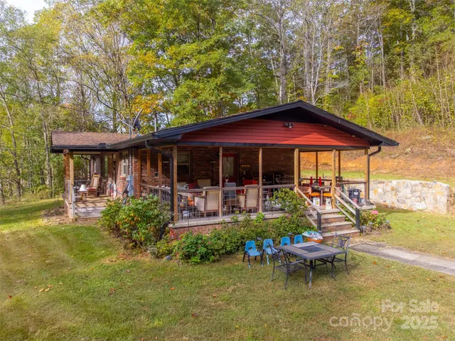 a view of a house with pool table and chairs under an umbrella