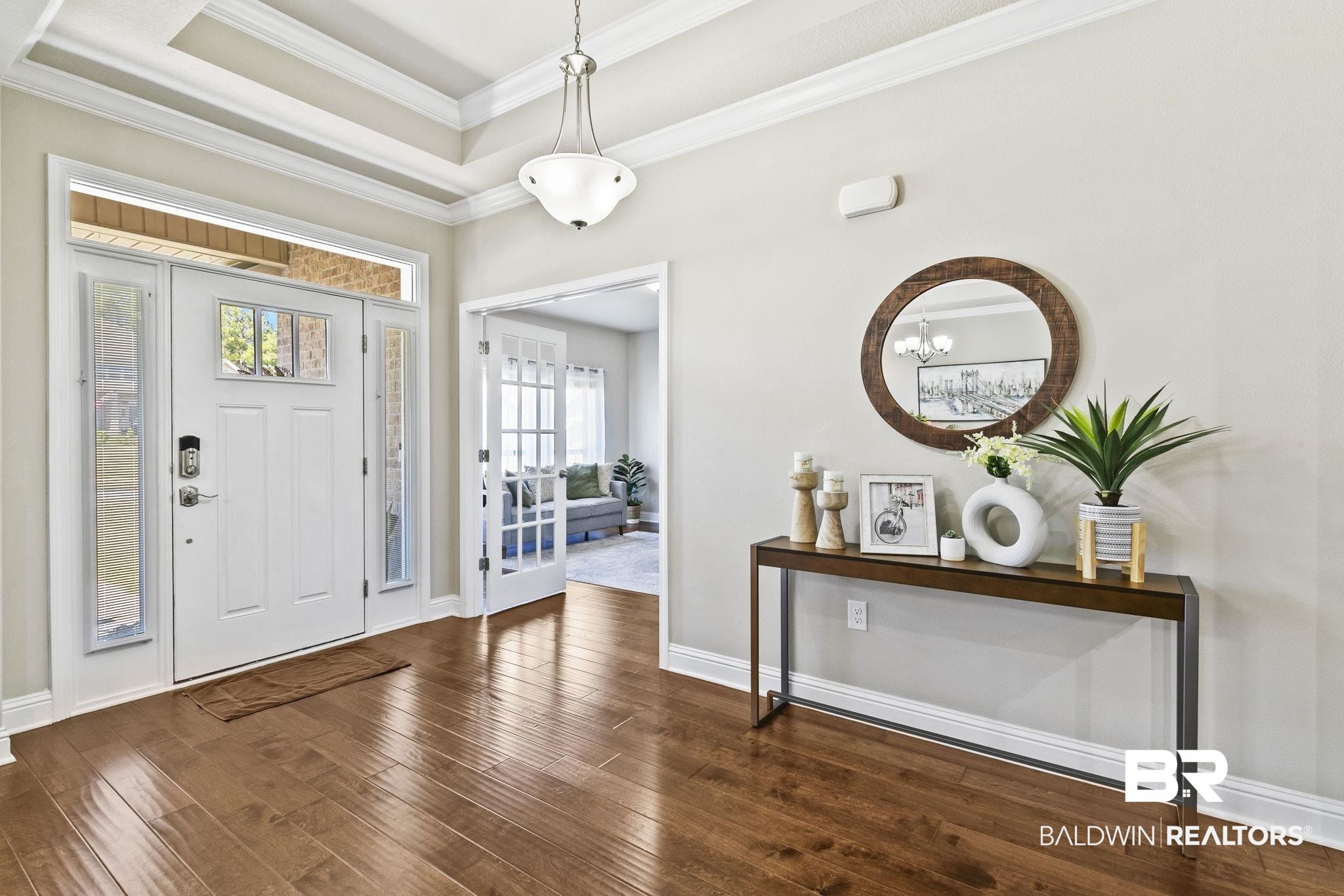 31500 Spoonbill Road Daphne, AL 36527 - Photo 7 of 85 Entryway featuring a notable chandelier, dark hardwood / wood-style floors, crown molding, and a tray ceiling