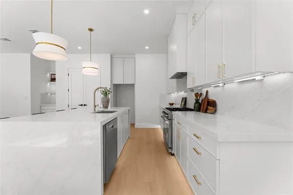a kitchen with kitchen island a sink stainless steel appliances and cabinets
