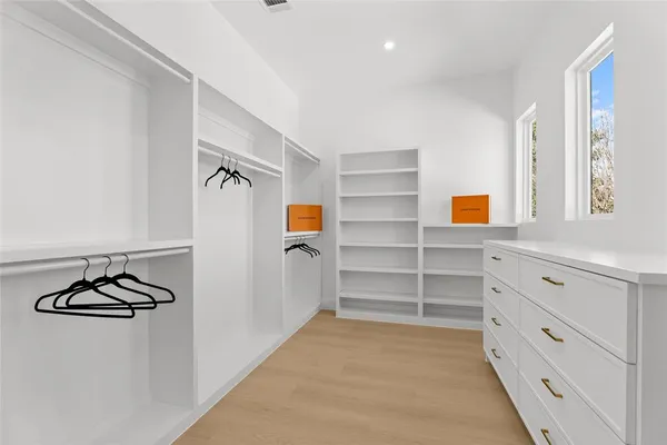 a view of walk in closet with empty racks