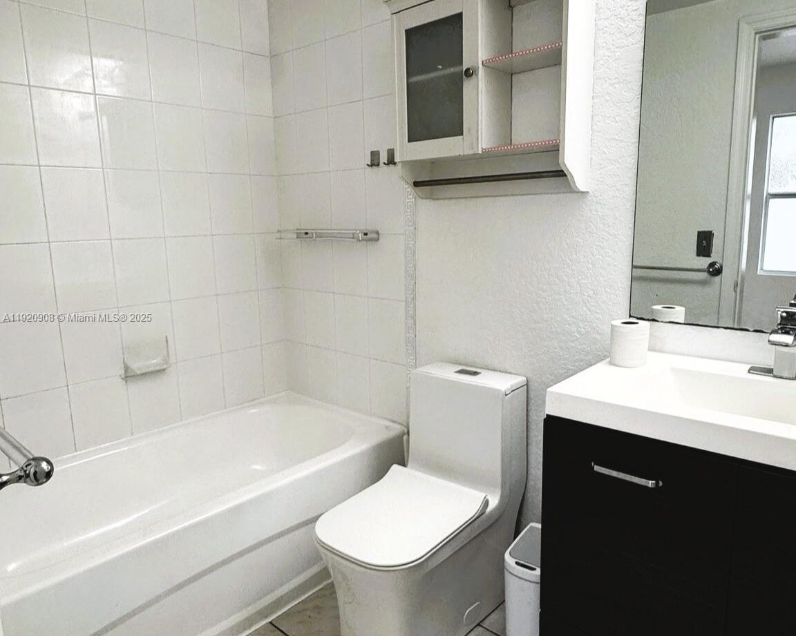 7326 Collins Avenue, Unit 205 Miami Beach, FL 33141 - Photo 11 of 15 a bathroom with a sink a toilet and shower