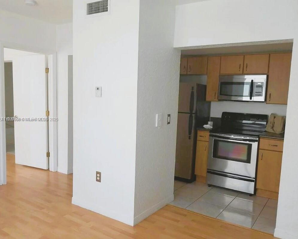 7326 Collins Avenue, Unit 205 Miami Beach, FL 33141 - Photo 2 of 15 a kitchen with a refrigerator and a stove