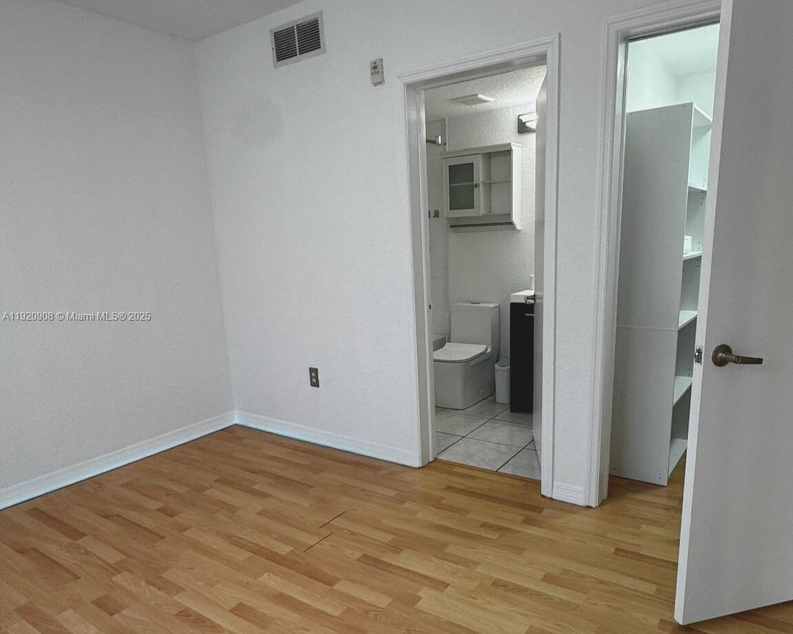 7326 Collins Avenue, Unit 205 Miami Beach, FL 33141 - Photo 9 of 15 a view of a room with wooden floor and bathroom